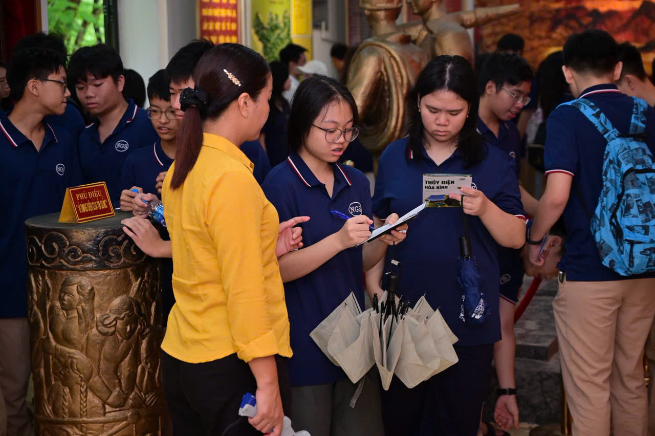 Học sinh điền phiếu tìm hiểu tại nhà truyền thống dưới sự hướng dẫn của cán bộ EVN