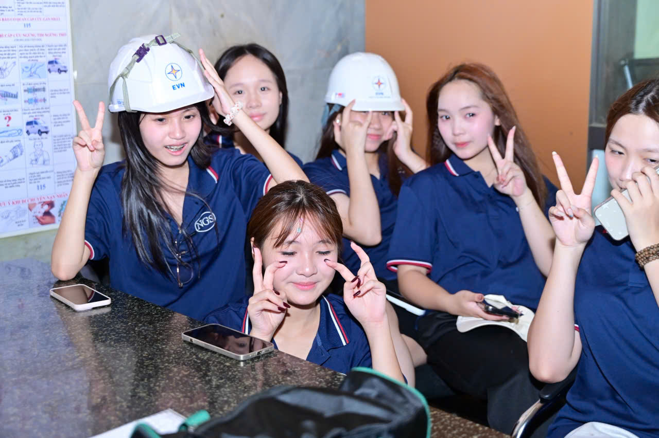 Nhóm nữ sinh đội mũ bảo hộ EVN, tạo dáng vui vẻ